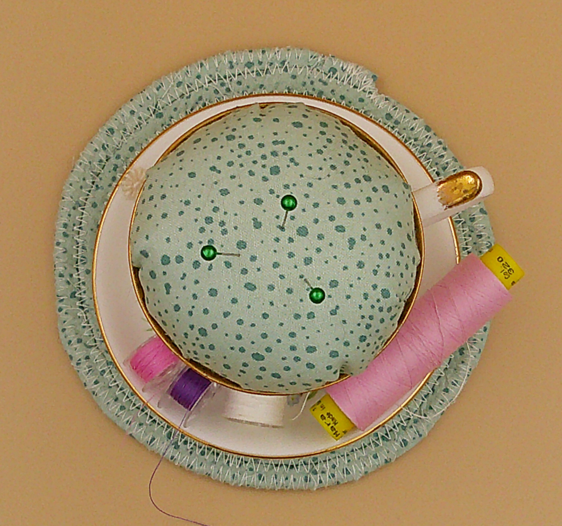 This is looking straight down on the pincushion bobbin holder sitting on top of the trivet. Bobbins and thread are an example not for sale. This is looking straight down on the pincushion bobbin holder sitting on top of the trivet. Bobbins and thread are an example not for sale.